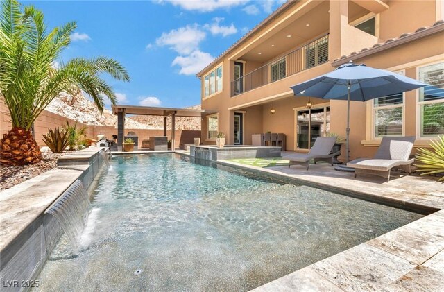 view of swimming pool featuring pool water feature and a patio