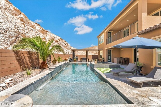 view of swimming pool with a mountain view, a patio area, exterior bar, and pool water feature