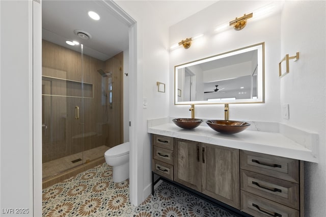 bathroom featuring toilet, ceiling fan, tile patterned flooring, an enclosed shower, and vanity