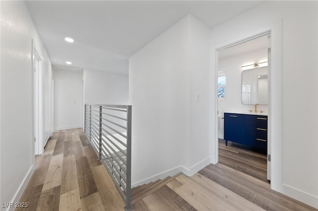 hallway with sink and light hardwood / wood-style floors