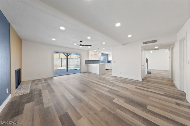 unfurnished living room with ceiling fan and light hardwood / wood-style floors