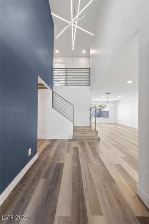 unfurnished living room featuring wood-type flooring and a notable chandelier