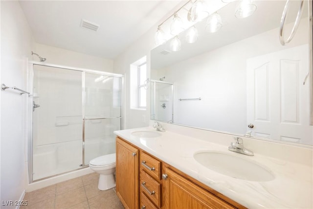 bathroom with toilet, tile patterned floors, vanity, and a shower with shower door