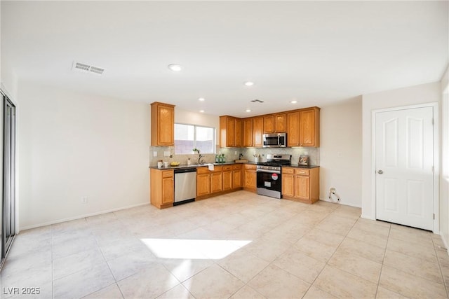 kitchen with light tile patterned floors, appliances with stainless steel finishes, and decorative backsplash