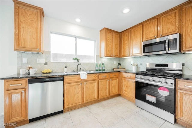 kitchen with light tile patterned floors, stainless steel appliances, tasteful backsplash, dark stone countertops, and sink