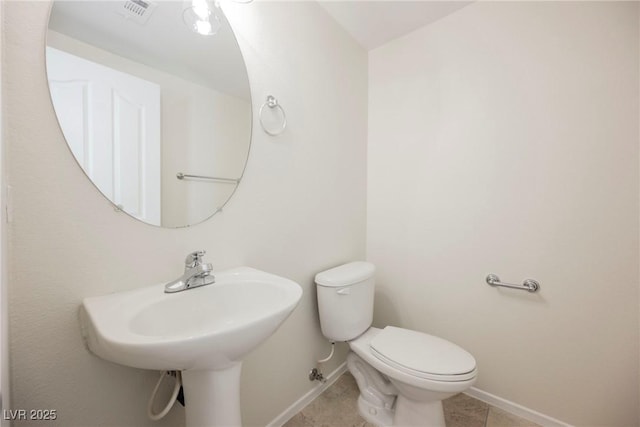 bathroom featuring toilet, tile patterned flooring, and sink