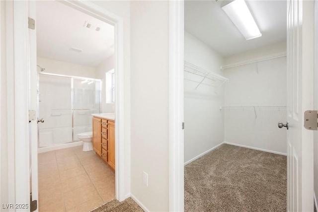 spacious closet featuring light colored carpet