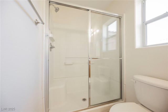 bathroom featuring an enclosed shower and toilet