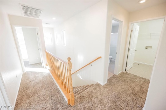 corridor featuring light colored carpet