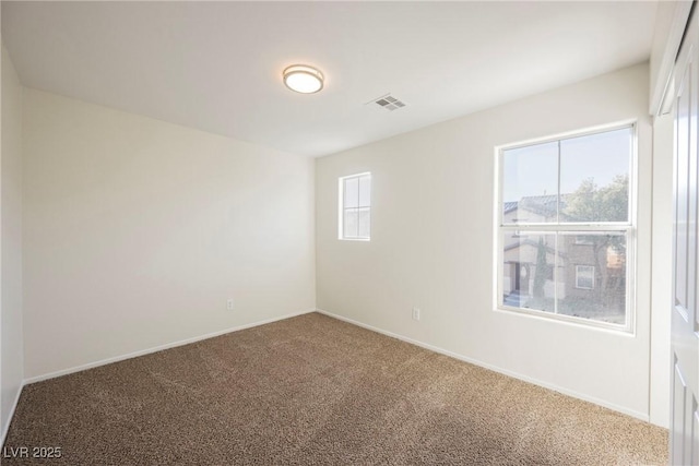 carpeted spare room featuring a healthy amount of sunlight