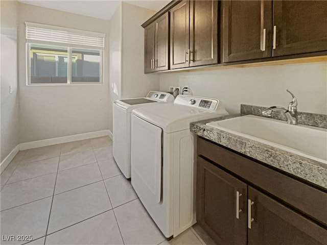 washroom featuring cabinets, separate washer and dryer, light tile patterned floors, and sink