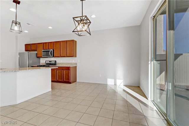 kitchen with light tile patterned flooring, stainless steel appliances, pendant lighting, and light stone countertops