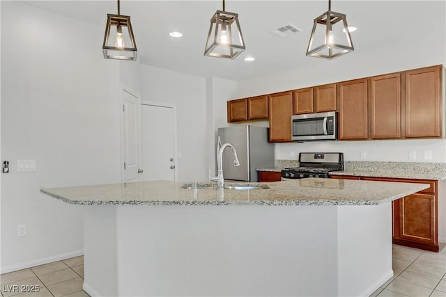 kitchen featuring stainless steel appliances, a center island with sink, hanging light fixtures, and sink