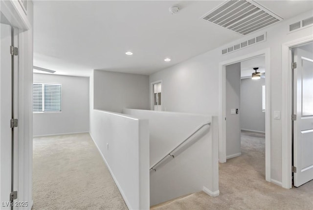 hallway featuring light colored carpet