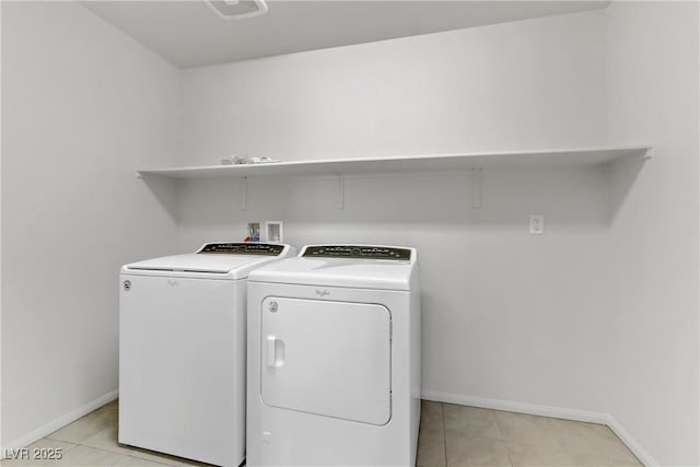 washroom with light tile patterned floors and washer and clothes dryer