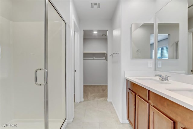 bathroom featuring vanity, tile patterned flooring, and a shower with door