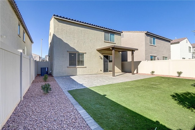 back of house featuring a patio area, a yard, and central AC