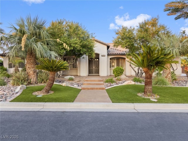 mediterranean / spanish-style home with a front yard