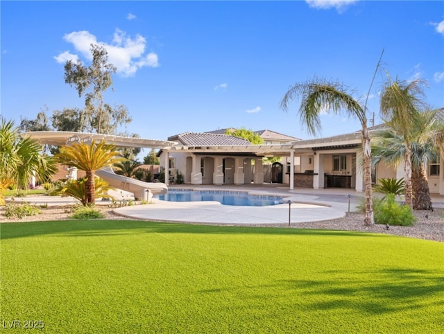 view of swimming pool with a yard, a water slide, and a patio