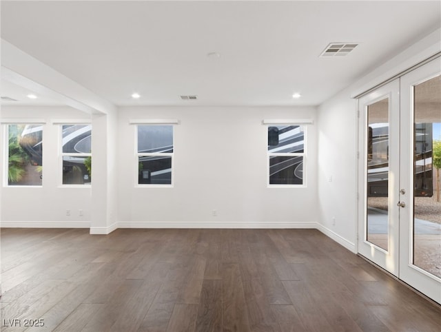 empty room featuring dark hardwood / wood-style flooring, a healthy amount of sunlight, and french doors