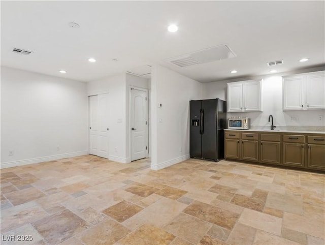 kitchen featuring white cabinets, black refrigerator with ice dispenser, and sink