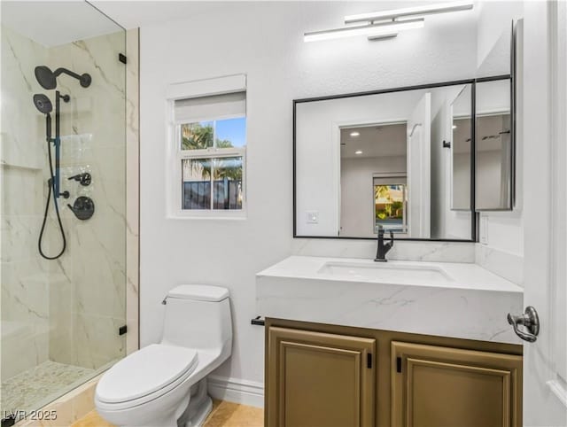 bathroom with toilet, vanity, and tiled shower