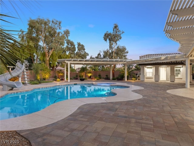 view of swimming pool featuring a pergola, a water slide, a patio, and an in ground hot tub