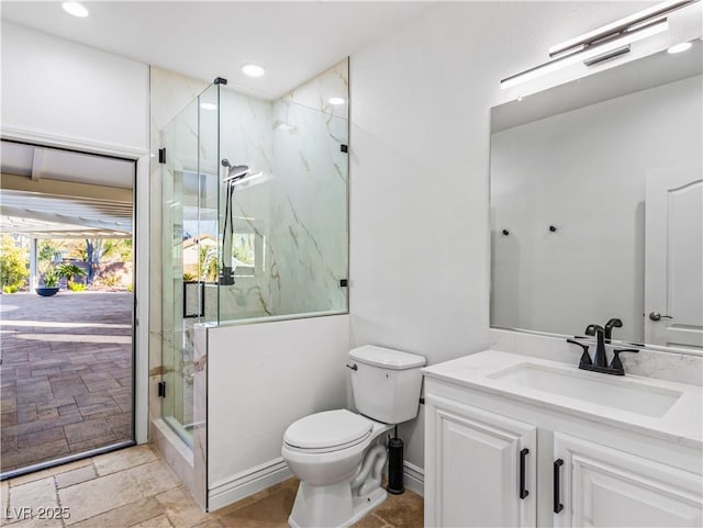 bathroom featuring a shower with shower door, toilet, and vanity