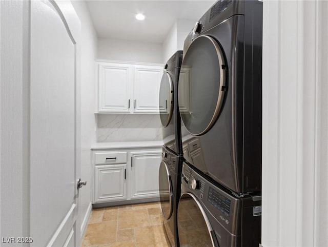 laundry room featuring cabinets and stacked washing maching and dryer