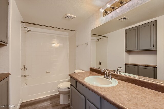 full bathroom with toilet, hardwood / wood-style flooring, vanity, and shower / bathing tub combination