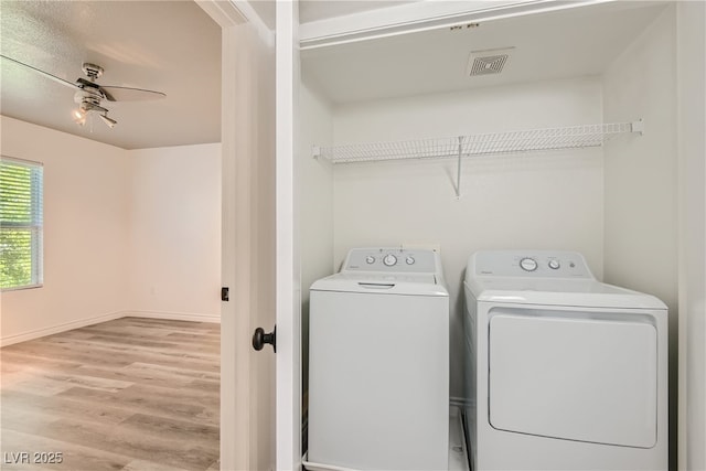 clothes washing area featuring ceiling fan, washing machine and dryer, and light hardwood / wood-style floors