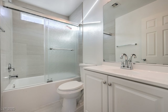 full bathroom featuring toilet, bath / shower combo with glass door, tile patterned floors, and vanity