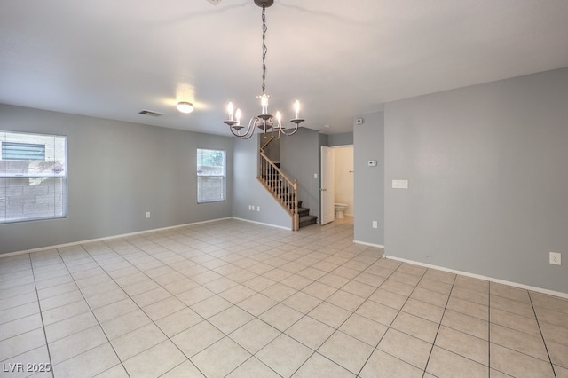 unfurnished room featuring an inviting chandelier and light tile patterned floors