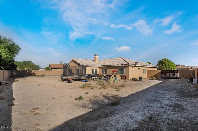 rear view of property featuring a trampoline