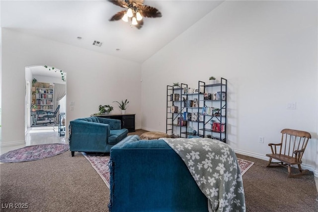 carpeted living room with ceiling fan and lofted ceiling