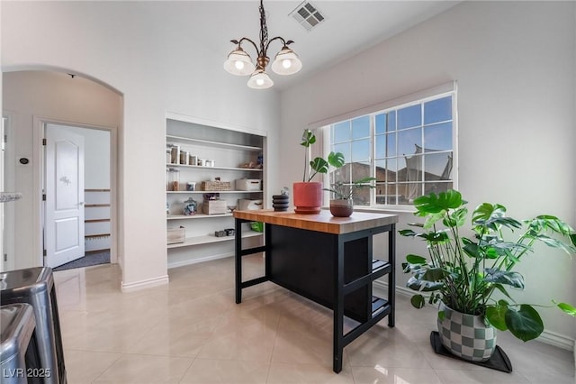 tiled home office featuring a chandelier and built in shelves