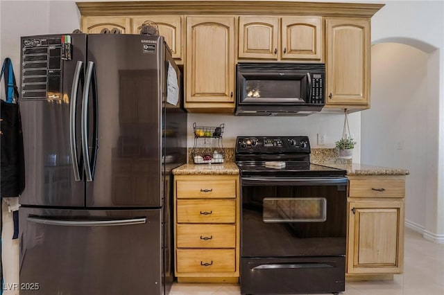 kitchen with black appliances, light tile patterned floors, light brown cabinetry, and light stone counters