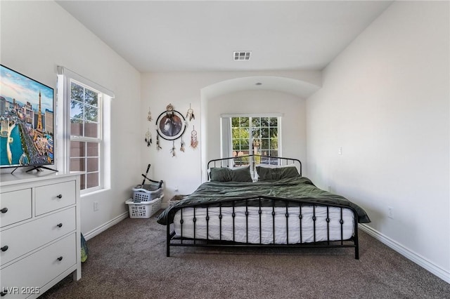 bedroom with multiple windows and dark colored carpet