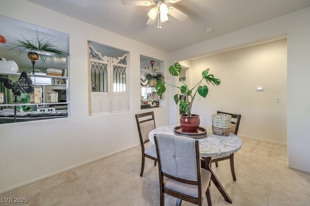 dining space with built in shelves and ceiling fan