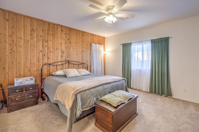 carpeted bedroom with ceiling fan and wooden walls