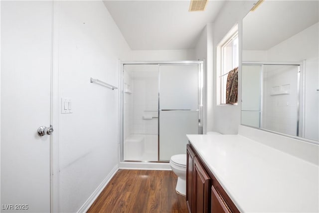 bathroom featuring toilet, walk in shower, hardwood / wood-style floors, and vanity