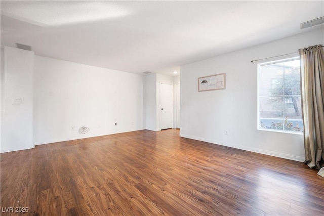 empty room with dark hardwood / wood-style flooring