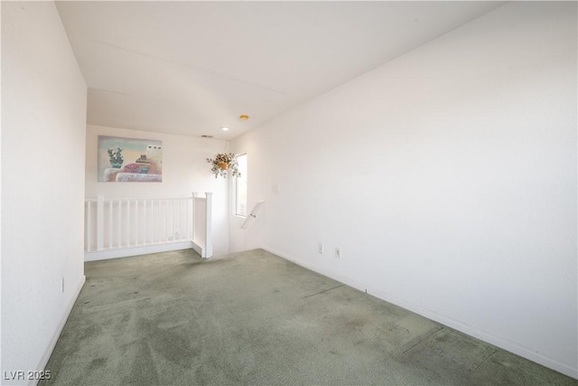 carpeted spare room featuring an inviting chandelier