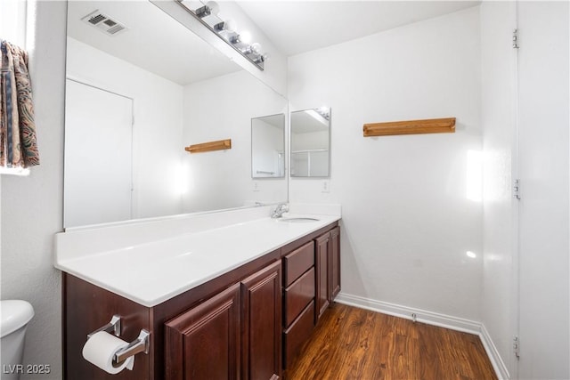 bathroom with toilet, hardwood / wood-style flooring, and vanity