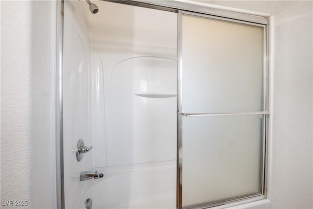 bathroom with combined bath / shower with glass door