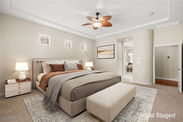 carpeted bedroom with ceiling fan and a tray ceiling