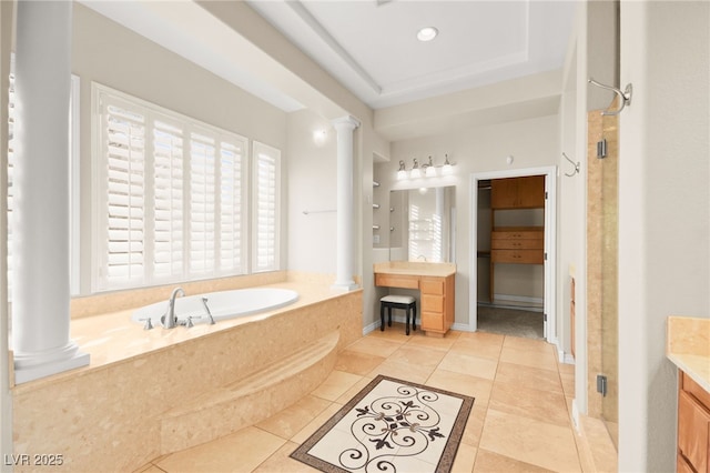 bathroom with decorative columns, a raised ceiling, independent shower and bath, tile patterned floors, and vanity