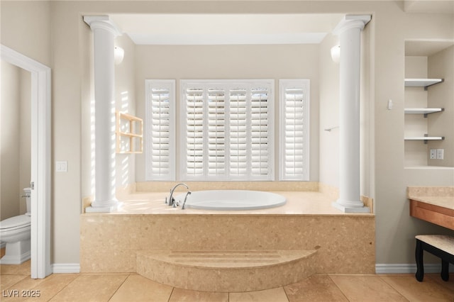 bathroom with built in shelves, tile patterned floors, ornate columns, a tub to relax in, and toilet