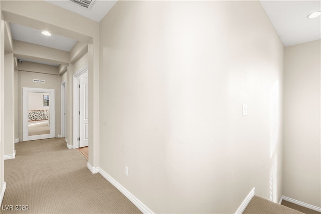 hallway featuring light colored carpet