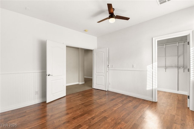 unfurnished bedroom with ceiling fan, a closet, and dark hardwood / wood-style flooring